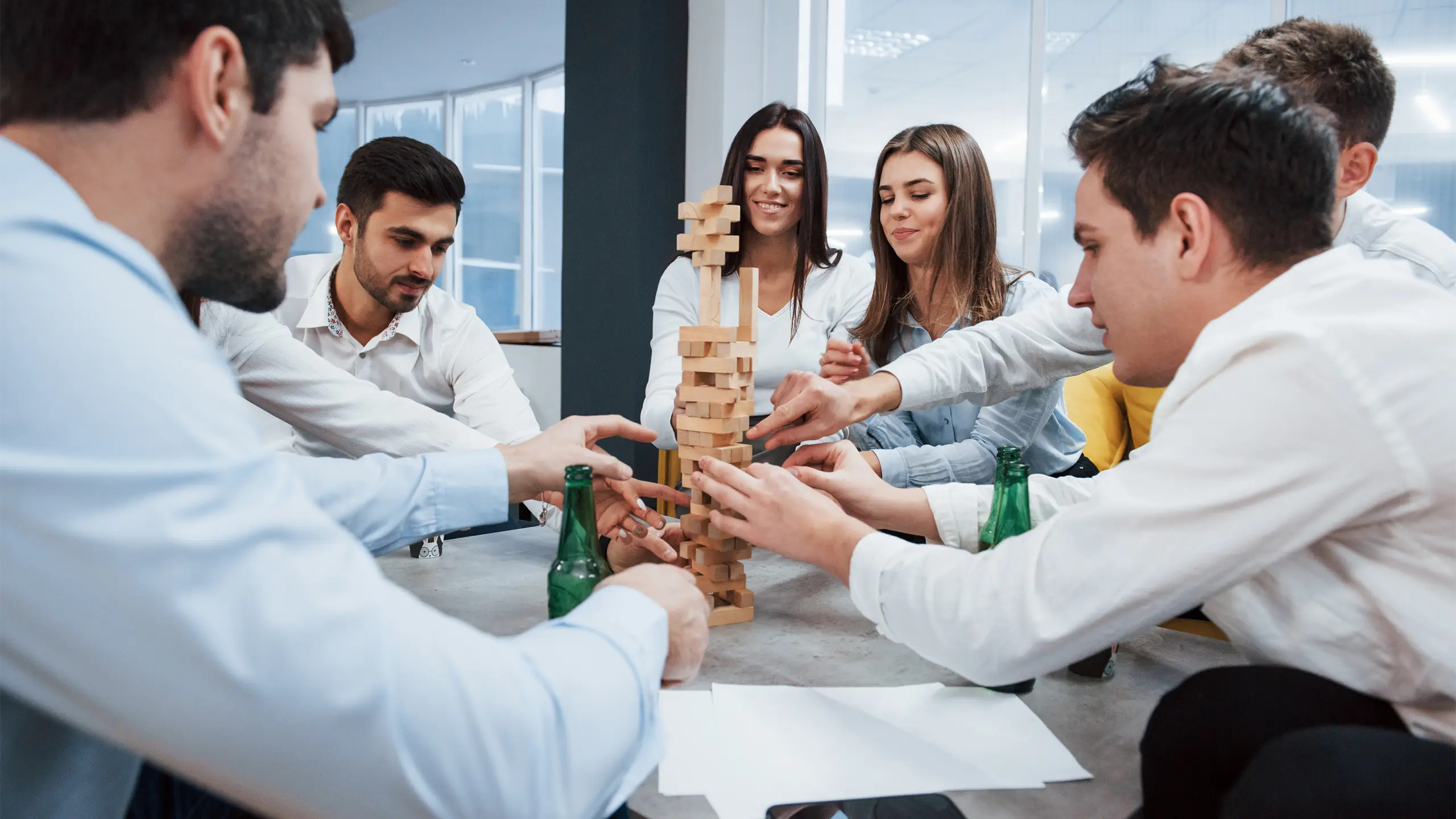 it-s-almost-fall-celebrating-successful-deal-young-office-workers-sitting-near-table-with-alcohol